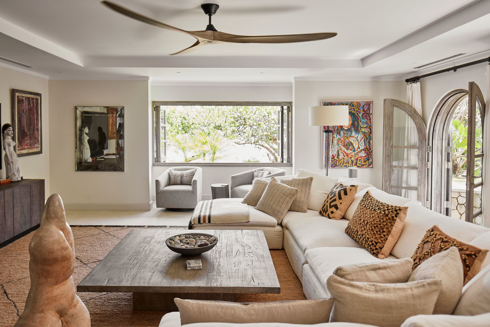 living room, sofa, sectional, coffee table, ceiling fan, arch openings, arch door, wall painting, timber, wood, island style, tropical design, throw pillows, warm