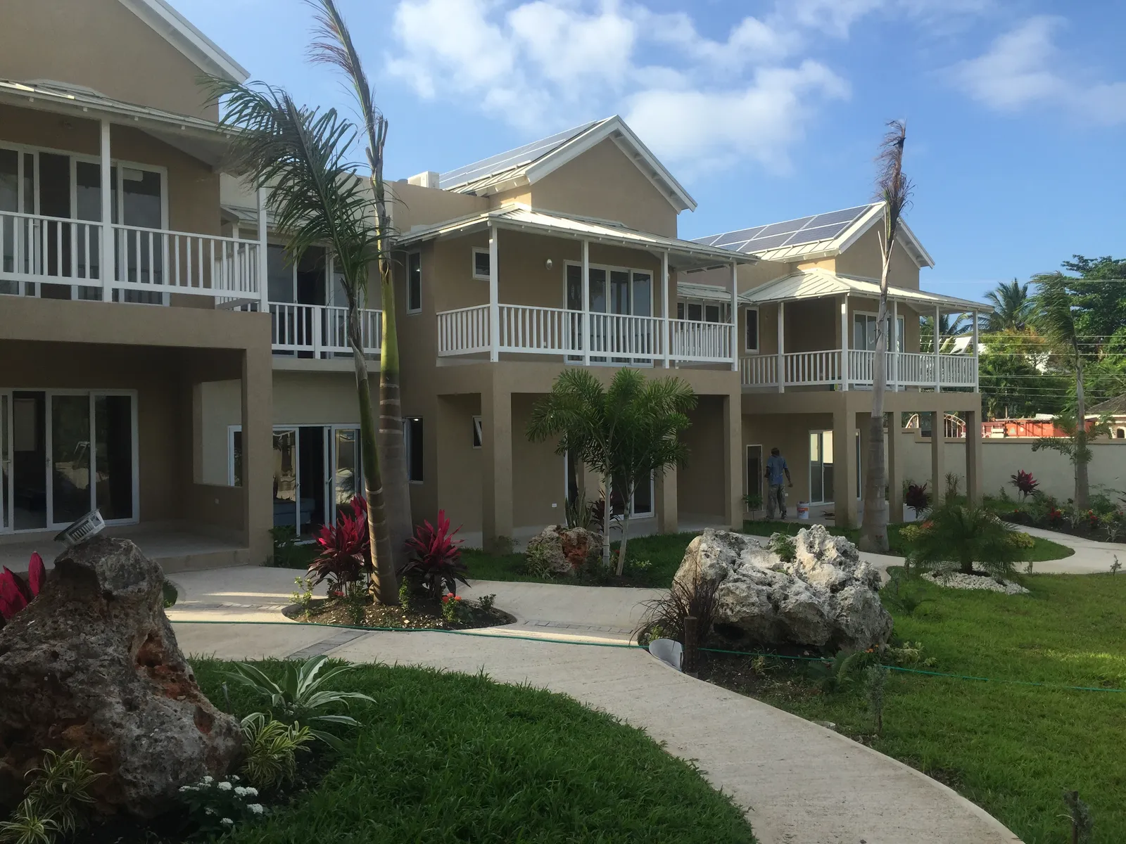 amenity zone with pavilion and new swimming pool, workers crossing the landscaped lawn.